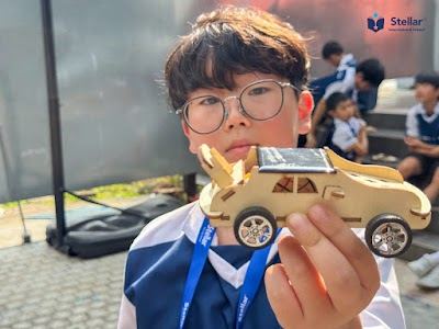 孩子拿着亲手做的太阳能车