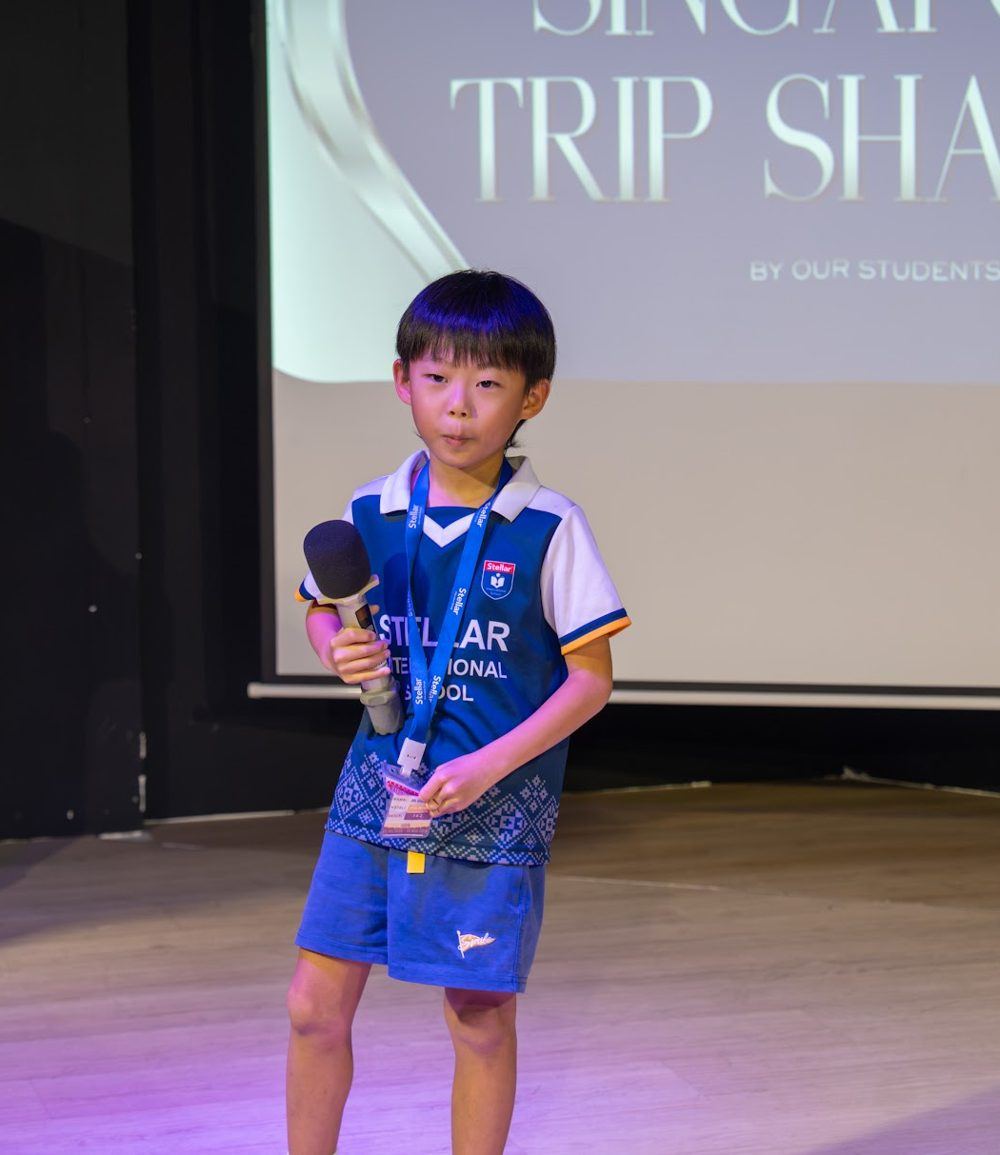 孩子在台上拿着麦克风分享新加坡之旅